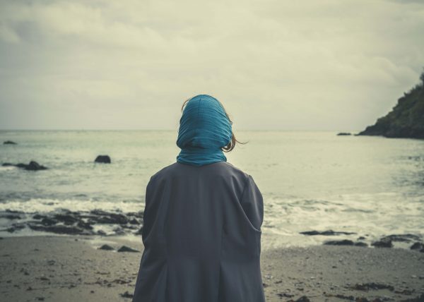 Woman with headscarf on beach 